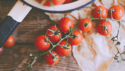 A dozen or so vine-ripened tomatoes sitting on a table.